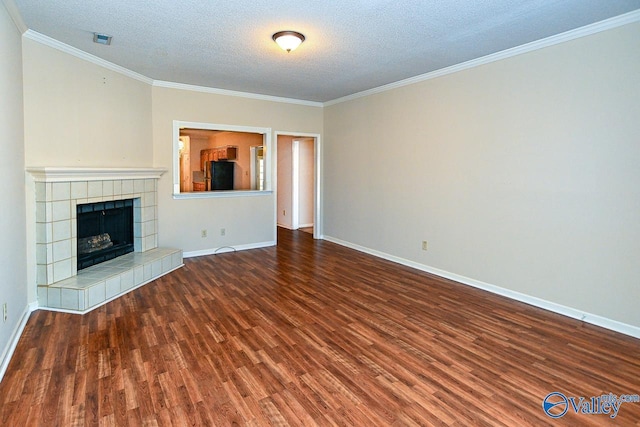 unfurnished living room with a textured ceiling, a fireplace, wood finished floors, baseboards, and crown molding