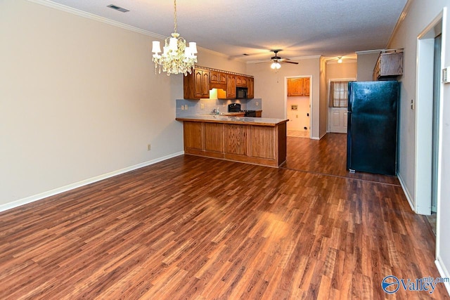 kitchen with dark wood finished floors, brown cabinetry, ornamental molding, a peninsula, and black appliances