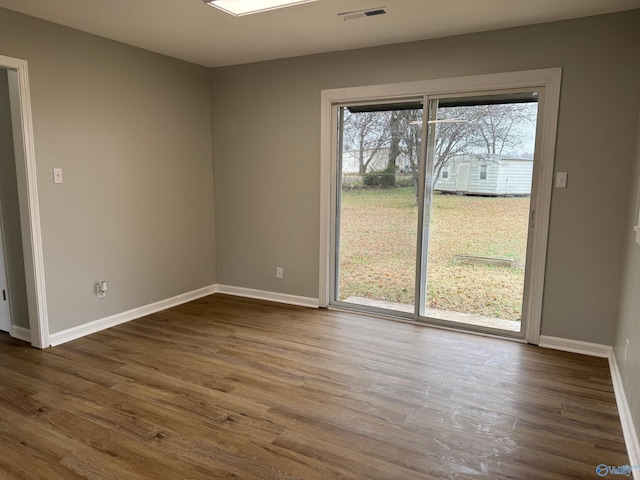 unfurnished room with a wealth of natural light and dark wood-type flooring