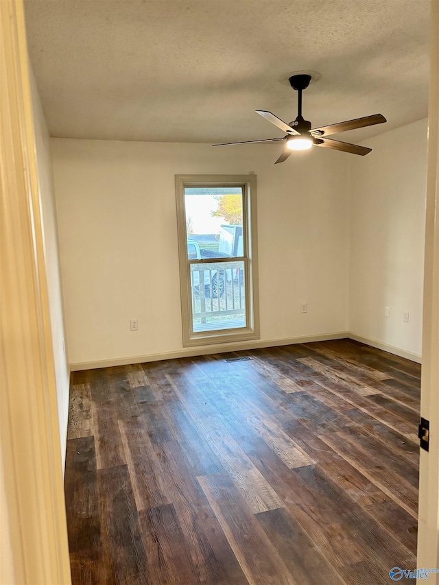 spare room featuring a textured ceiling, dark hardwood / wood-style floors, and ceiling fan