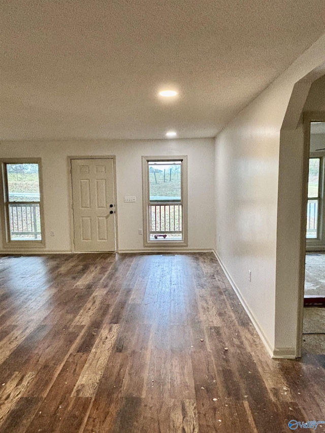 interior space featuring a textured ceiling and dark wood-type flooring