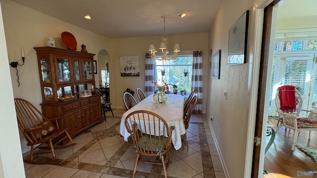 dining room with light tile patterned floors and a notable chandelier