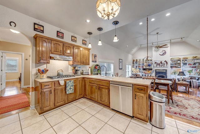 kitchen with decorative light fixtures, vaulted ceiling, sink, and stainless steel appliances