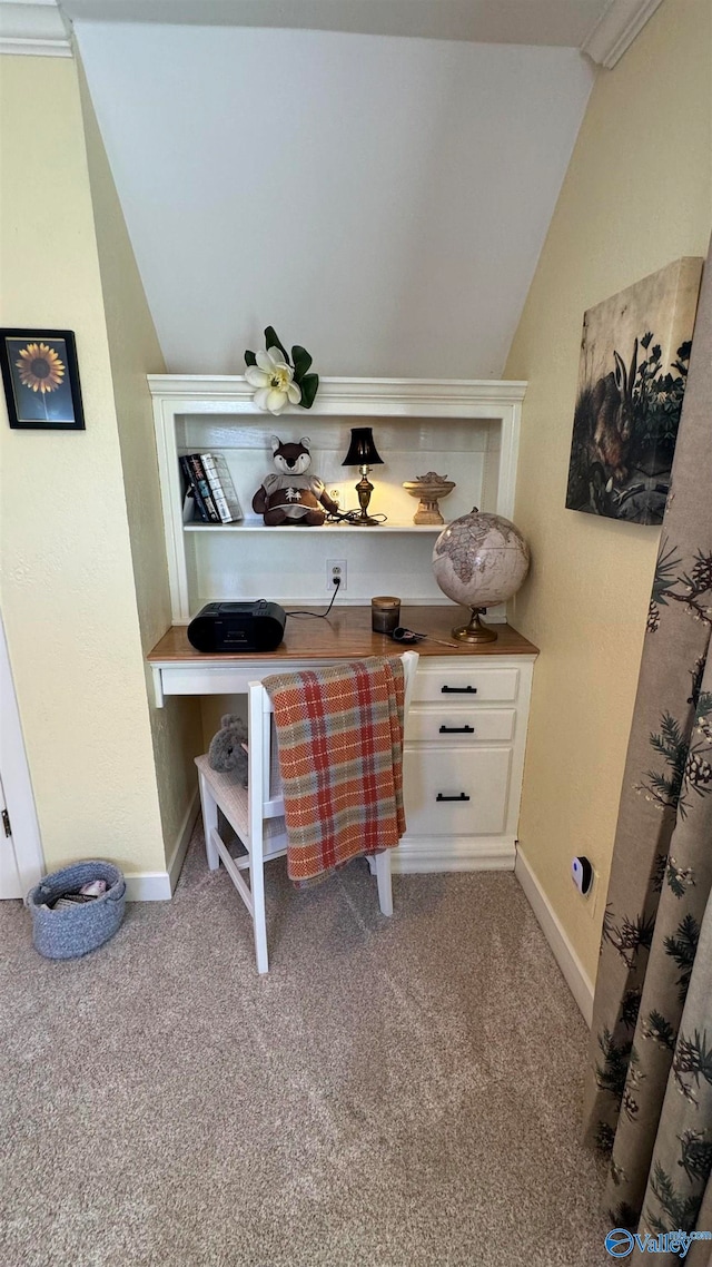 bar featuring built in desk, light colored carpet, vaulted ceiling, crown molding, and white cabinets