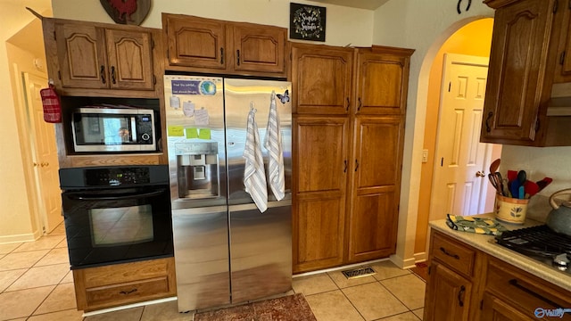 kitchen with light tile patterned floors and appliances with stainless steel finishes