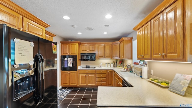 kitchen with a textured ceiling, black appliances, dark tile patterned flooring, kitchen peninsula, and sink