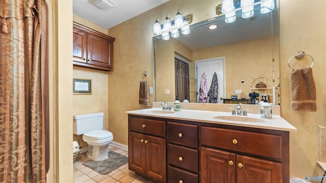 bathroom featuring vanity, toilet, and tile patterned flooring