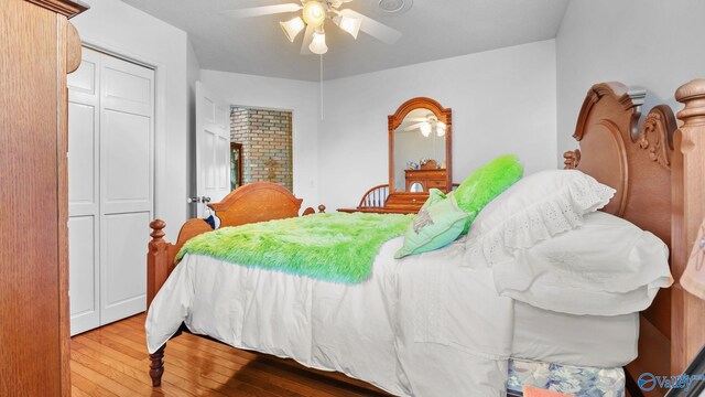 bedroom featuring vaulted ceiling, a textured ceiling, hardwood / wood-style flooring, and ceiling fan