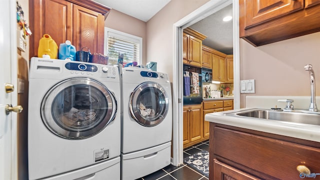 washroom with a textured ceiling, cabinets, independent washer and dryer, dark tile patterned flooring, and sink