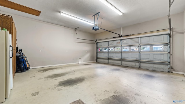 garage featuring white refrigerator and a garage door opener