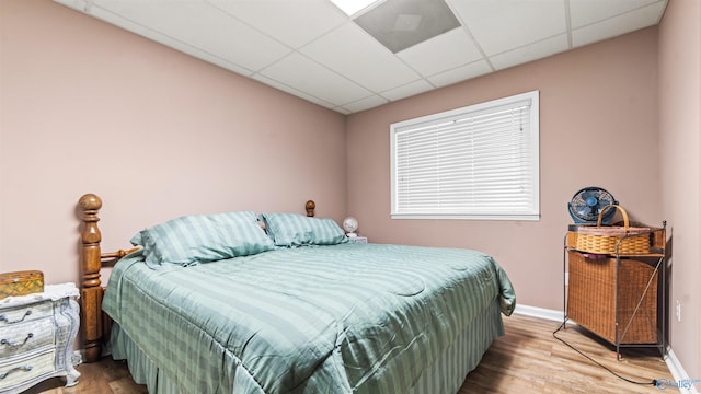 bedroom featuring hardwood / wood-style floors and a drop ceiling