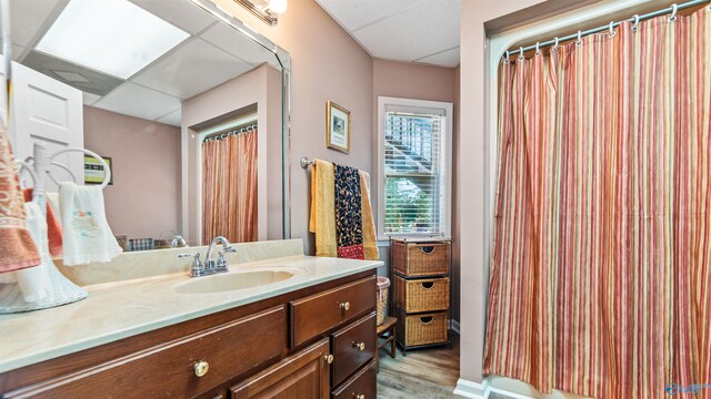 bathroom featuring vanity, wood-type flooring, and a paneled ceiling