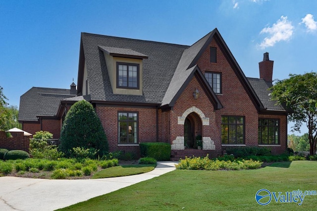 tudor home with a front lawn