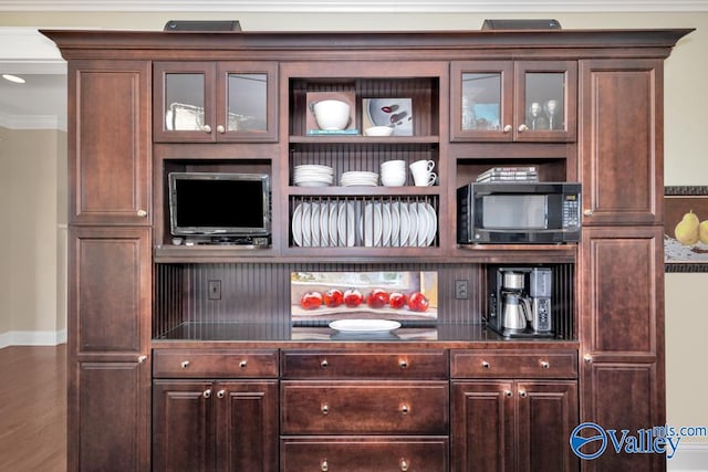 kitchen with dark brown cabinetry, wood-type flooring, and crown molding