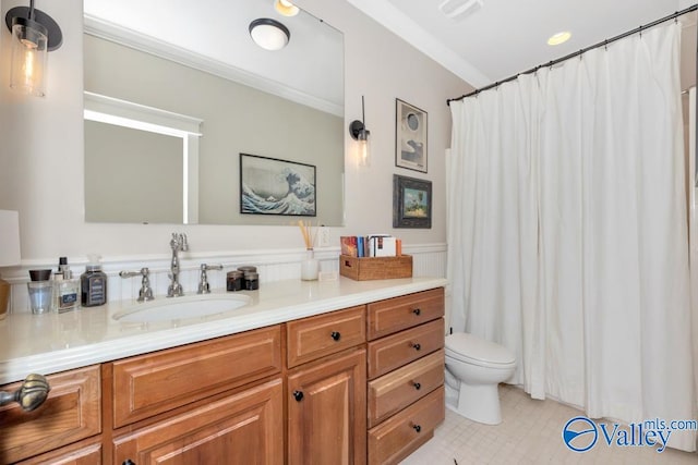 bathroom with tile patterned floors, toilet, ornamental molding, and vanity