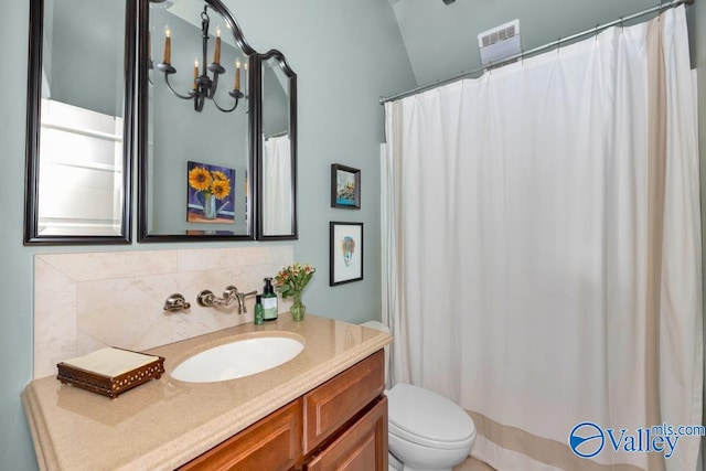 bathroom with vaulted ceiling, toilet, backsplash, and vanity