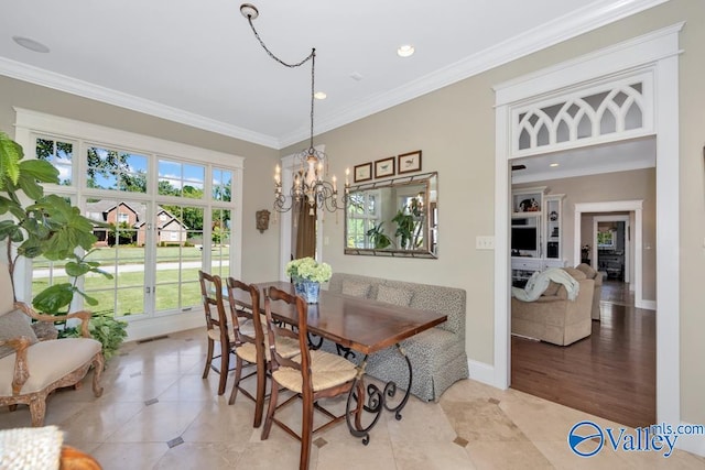 dining area with light wood-type flooring, a chandelier, and crown molding