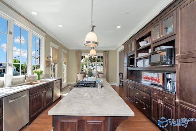 kitchen featuring a center island, appliances with stainless steel finishes, dark brown cabinets, and light hardwood / wood-style floors