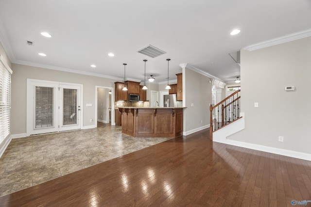 4513 Stone Park Cir, Owens Cross Roads, AL 35763 - kitchen with appliances with stainless steel finishes, brown cabinetry, open floor plan, a peninsula, and decorative light fixtures