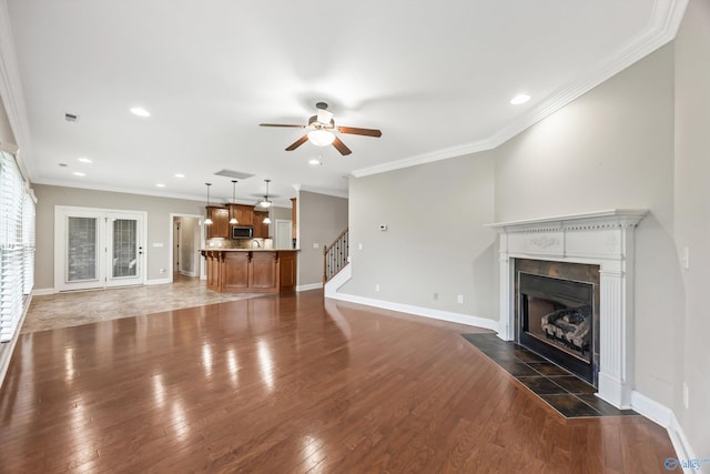 4513 Stone Park Cir, Owens Cross Roads, AL 35763 - unfurnished living room featuring a tiled fireplace, ceiling fan, dark wood-type flooring, ornamental molding, and recessed lighting