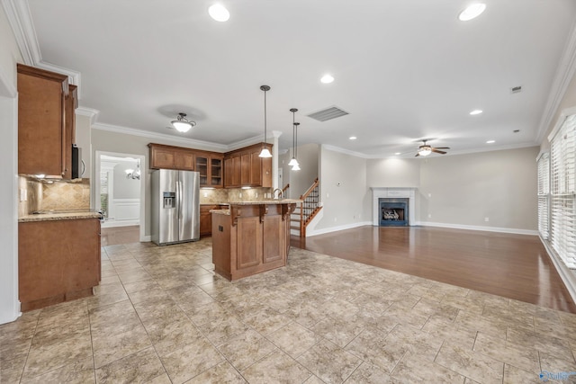 4513 Stone Park Cir, Owens Cross Roads, AL 35763 - kitchen featuring stainless steel refrigerator with ice dispenser, brown cabinets, a ceiling fan, tasteful backsplash, and a kitchen breakfast bar
