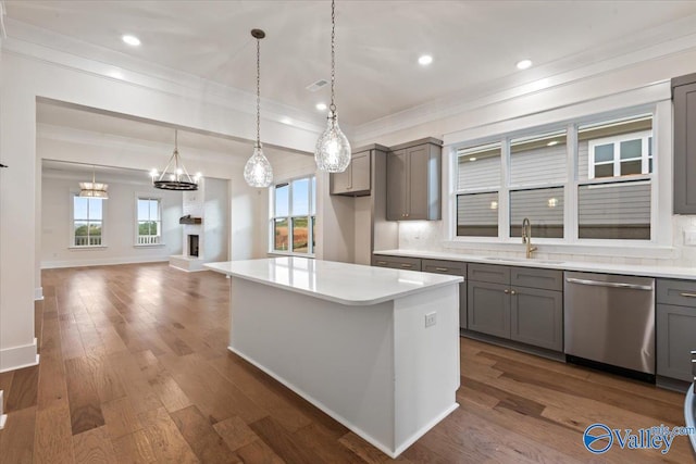 kitchen with sink, gray cabinets, stainless steel dishwasher, and a center island