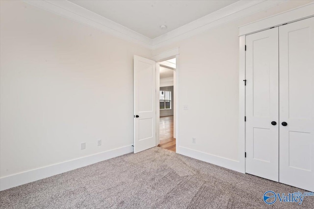 unfurnished bedroom featuring ornamental molding, carpet flooring, and a closet