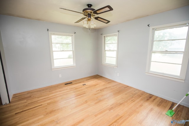 empty room with plenty of natural light, ceiling fan, and light hardwood / wood-style flooring
