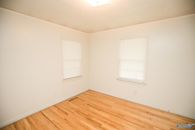 spare room featuring hardwood / wood-style floors and crown molding