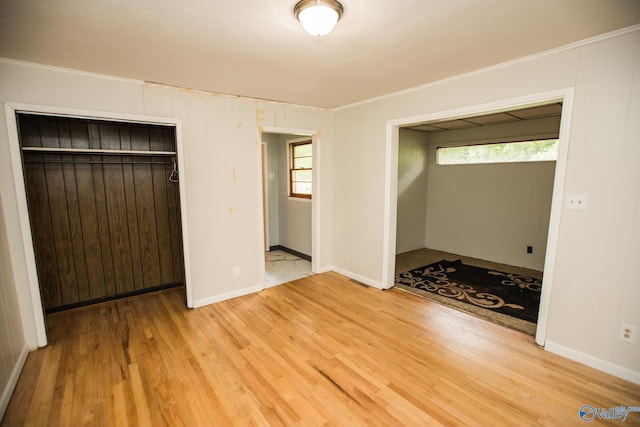 unfurnished bedroom with ornamental molding, hardwood / wood-style floors, and a closet