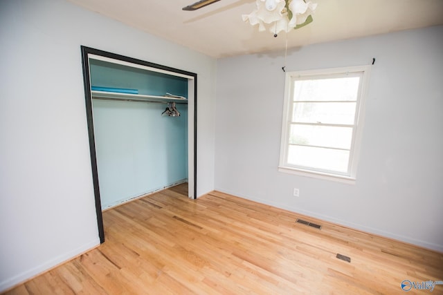 unfurnished bedroom featuring hardwood / wood-style flooring, ceiling fan, and a closet