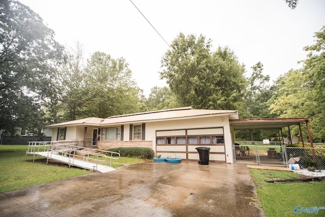 view of front of home featuring a carport, a garage, and a front lawn