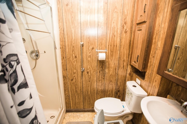 bathroom featuring a shower with shower curtain, wooden walls, sink, and toilet