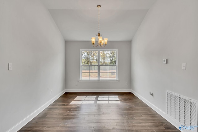 unfurnished dining area featuring a chandelier and dark wood-type flooring