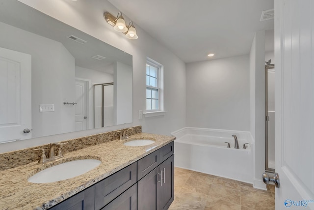 bathroom with vanity and shower with separate bathtub