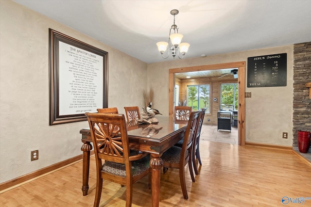 dining area featuring light wood-type flooring and an inviting chandelier