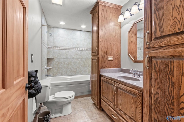 full bathroom with tile patterned floors, vanity, tiled shower / bath combo, and toilet