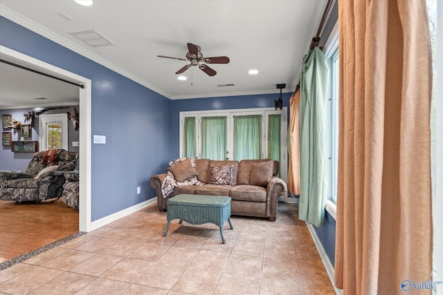 living room with ceiling fan, light wood-type flooring, and ornamental molding