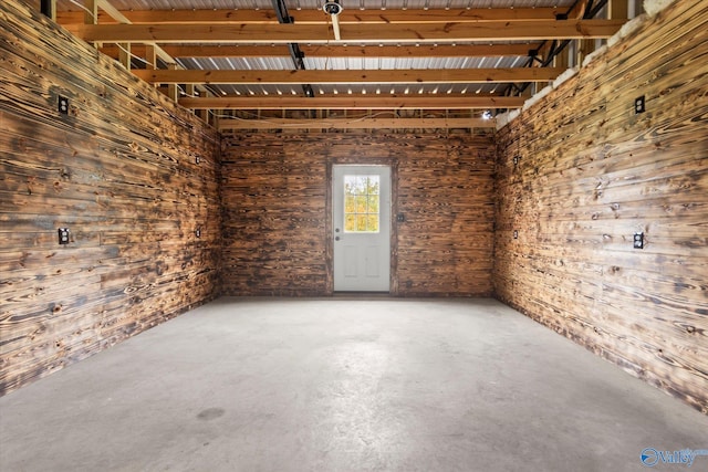 unfurnished room with concrete flooring and wooden walls