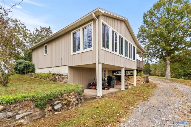 view of side of home with a lawn and a patio