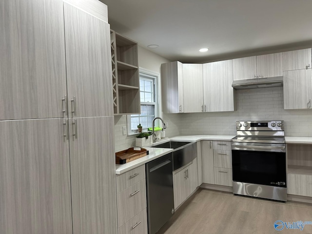 kitchen featuring stainless steel electric range oven, tasteful backsplash, black dishwasher, sink, and light hardwood / wood-style flooring