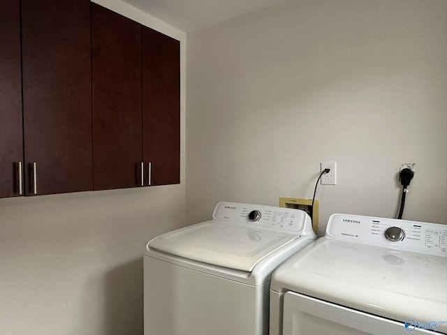 laundry room featuring cabinets and washing machine and dryer