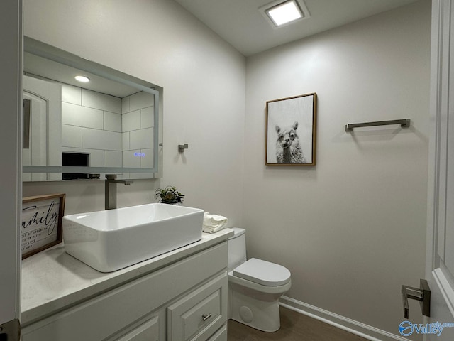 bathroom with vanity, hardwood / wood-style floors, and toilet