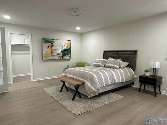 bedroom featuring hardwood / wood-style flooring, a spacious closet, and a closet