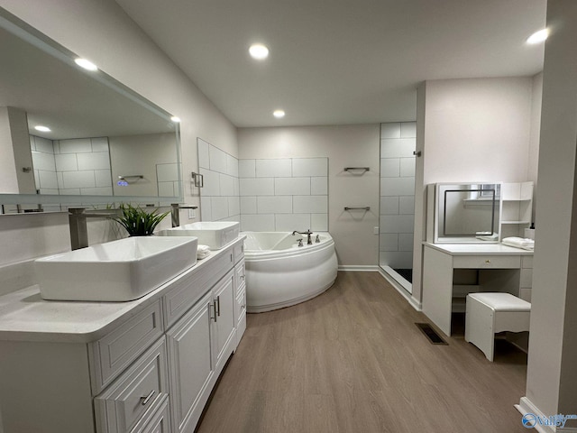 bathroom featuring hardwood / wood-style flooring, vanity, and shower with separate bathtub