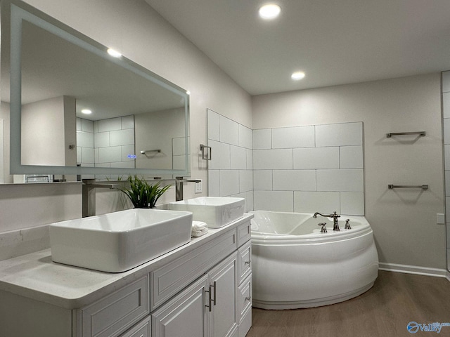 bathroom with wood-type flooring, vanity, and a bathtub