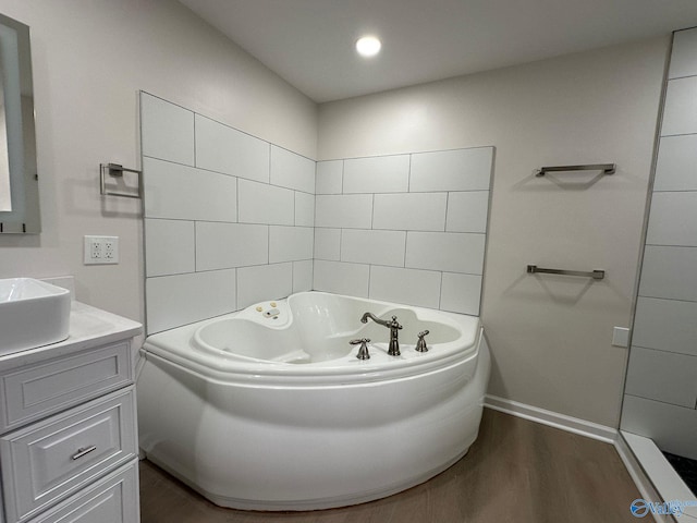 bathroom featuring vanity, hardwood / wood-style floors, and a bathtub