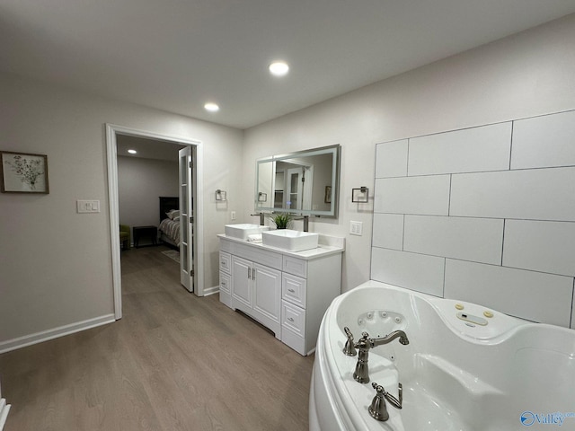 bathroom with vanity, hardwood / wood-style floors, and a tub