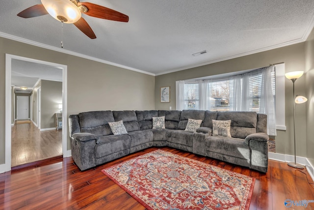 living room with a textured ceiling, ceiling fan, dark hardwood / wood-style flooring, and crown molding