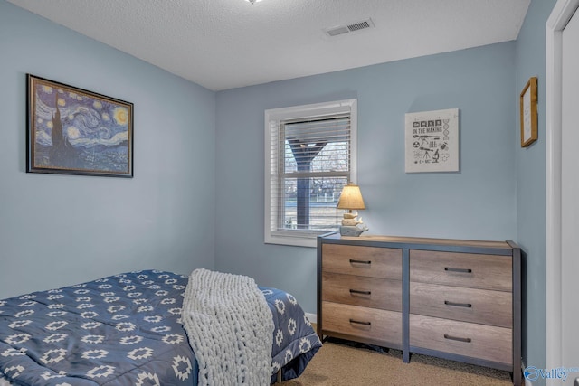 bedroom featuring carpet and a textured ceiling